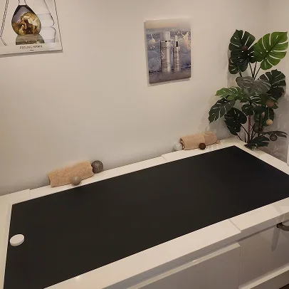 Table de massage en noir et blanc dans une salle de spa avec des plantes à Bois-d’Arcy près de Versailles dans les Yvelines 78