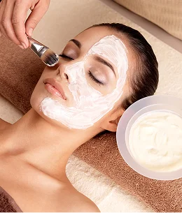 Femme recevant un masque facial blanc appliqué au pinceau dans un spa à Bois d'Arcy près de Versailles dans les Yvelines 78